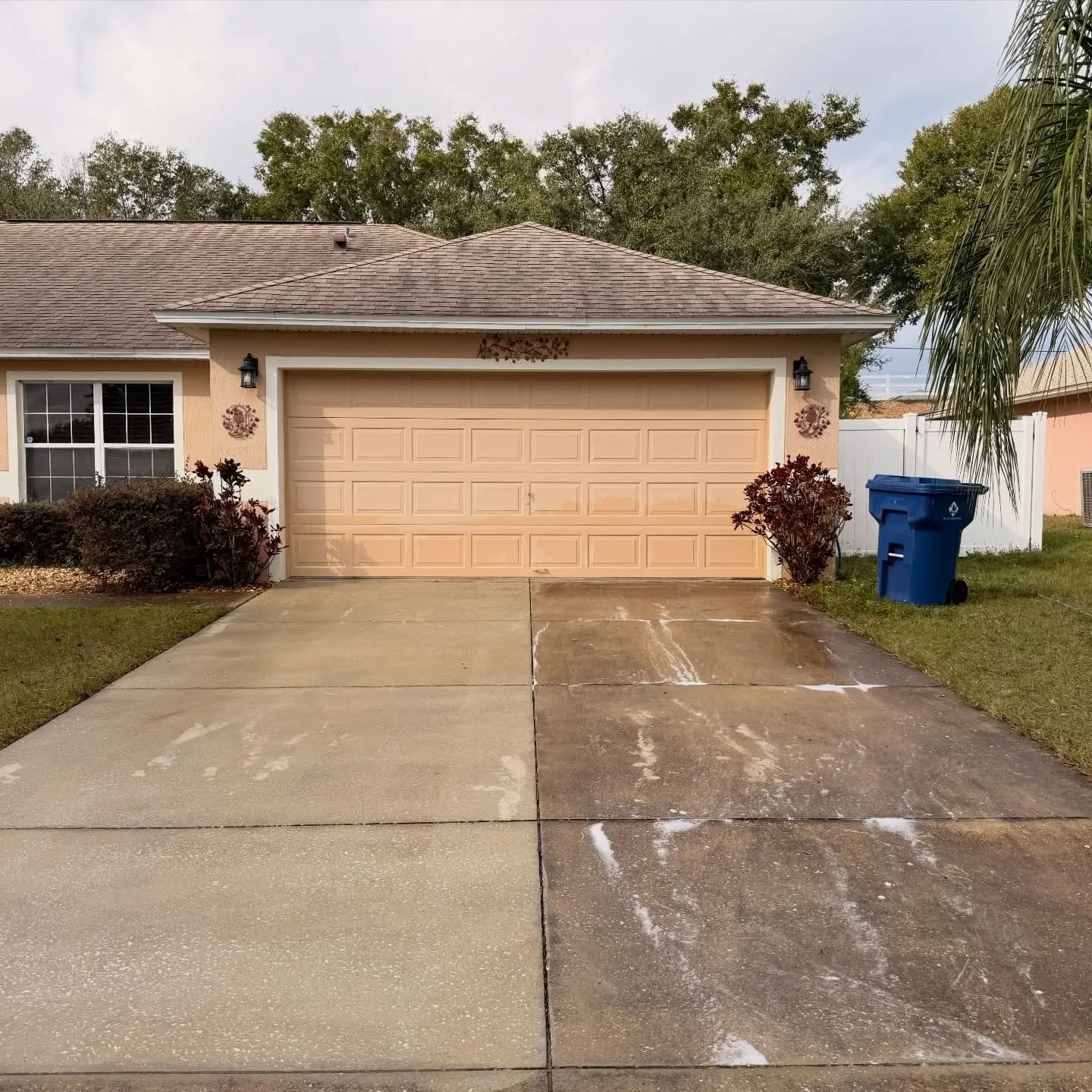 A concrete driveway cleaned to a like-new finish in front of a Florida home