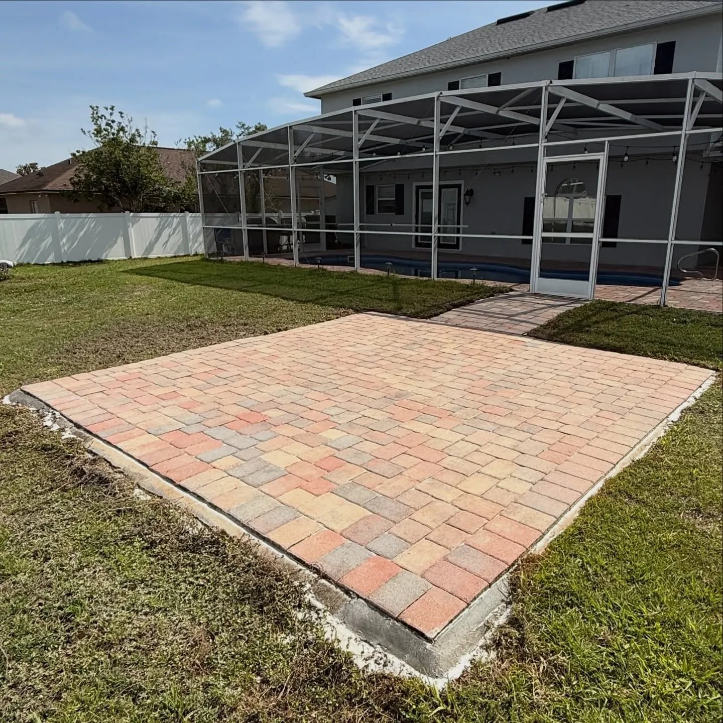 A screened pool patio with red brick pavers cleaned and restored